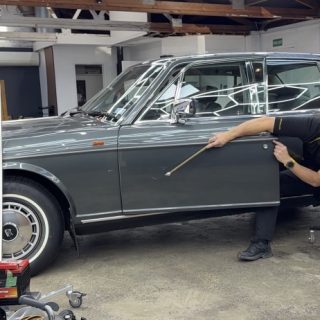 Dent Devils technician using paintless dent removal tools on a classic car door panel
